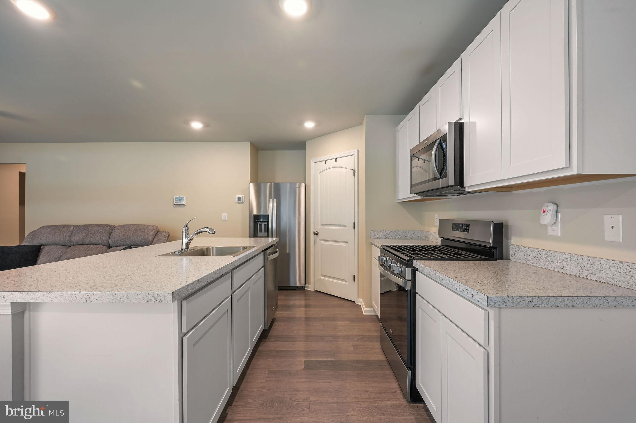 504 Currant Circle Magnolia, DE 19962 - Photo 9 of 27 a kitchen with stainless steel appliances granite countertop a sink stove and refrigerator
