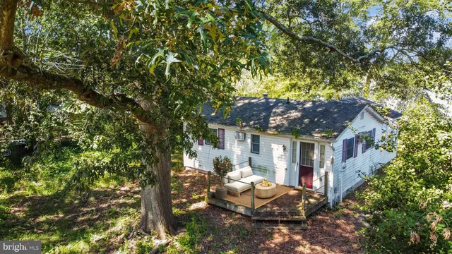 a backyard of a house with table and chairs under an umbrella