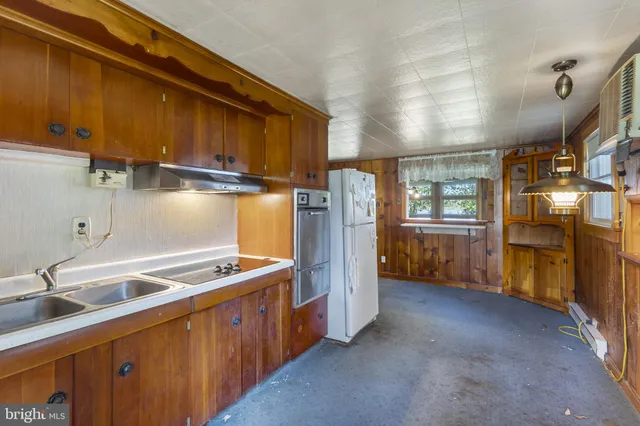 a kitchen with stainless steel appliances granite countertop a sink a stove and a refrigerator