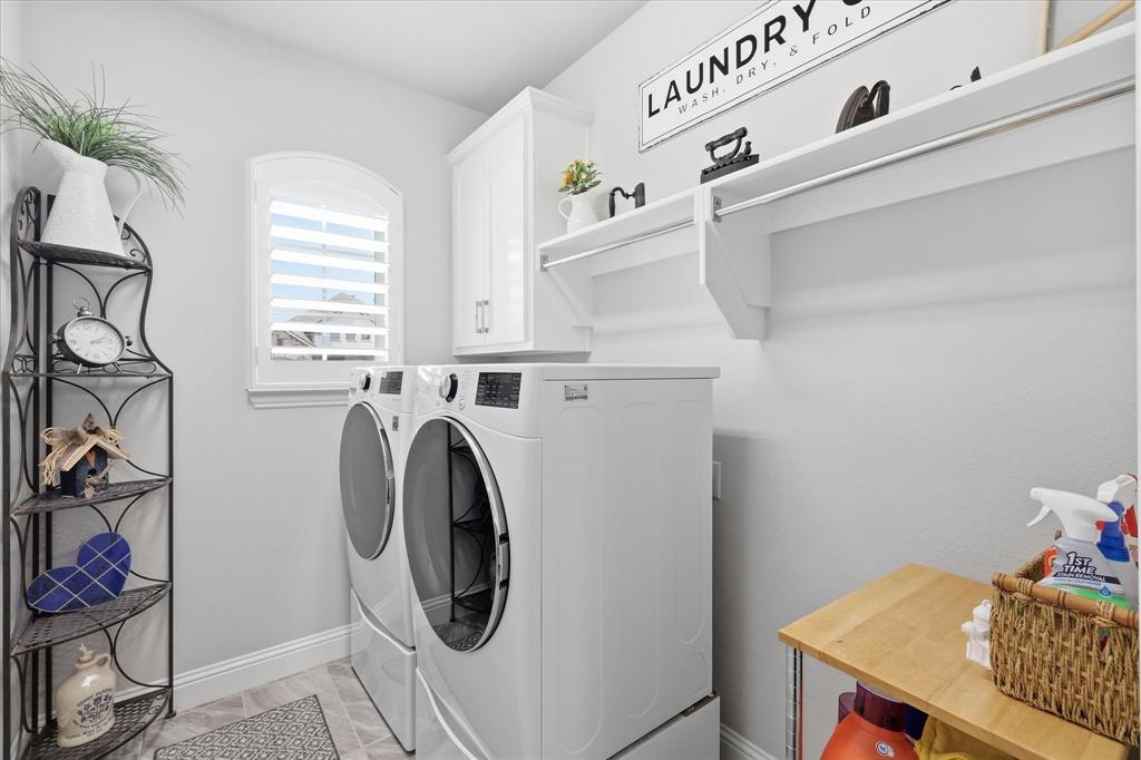 9708 Surveyor Road Oak Point, TX 75068 - Photo 31 of 34 Dedicated laundry room featuring light gray walls, an arched window with plantation shutters, upper cabinetry, and a hanging rod with shelving