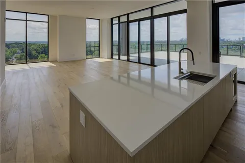 a view of a kitchen with a sink and large window