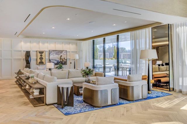 a living room with furniture large window and a table