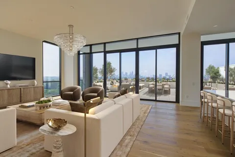 a living room with furniture large windows and a flat screen tv