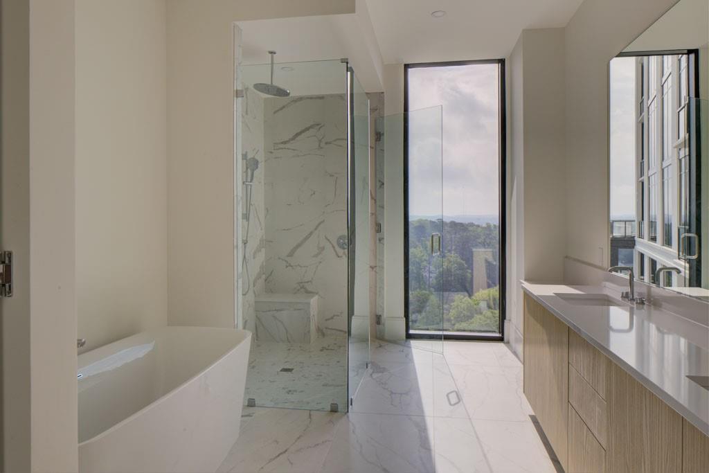2425 Peachtree Street Northeast, Unit 1505 Atlanta, GA 30305 - Photo 6 of 25 a bathroom with a granite countertop bathtub shower sink and mirror