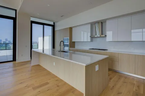 a kitchen with stainless steel appliances granite countertop a sink a stove and a wooden floors