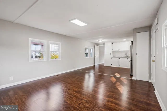 a view of a big room with wooden floor and windows