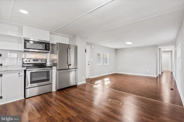a kitchen with granite countertop a refrigerator and a stove top oven