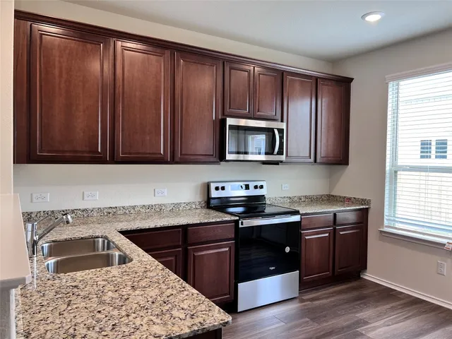 a kitchen with stainless steel appliances granite countertop a sink stove and microwave