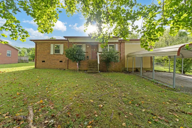 a view of a house with backyard and a tree