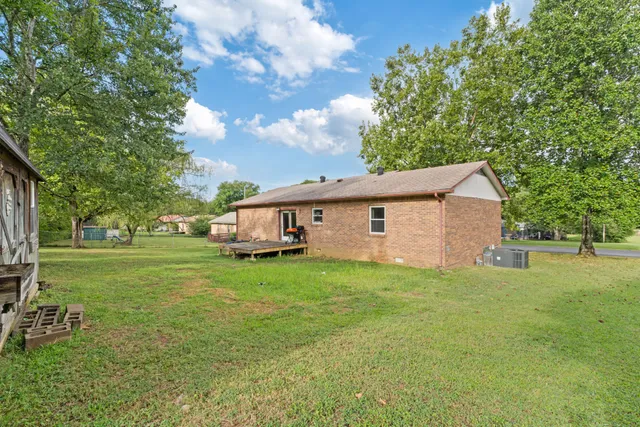 a view of a yard in front of a house with large trees