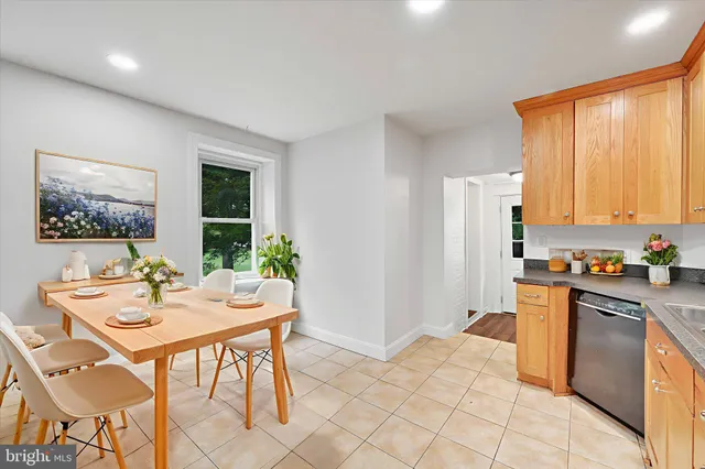 a kitchen with stainless steel appliances granite countertop a stove a refrigerator a dining table and chairs