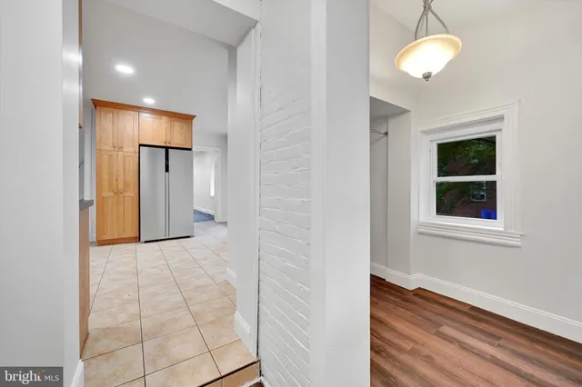 a view of a hallway with wooden floor and chandelier