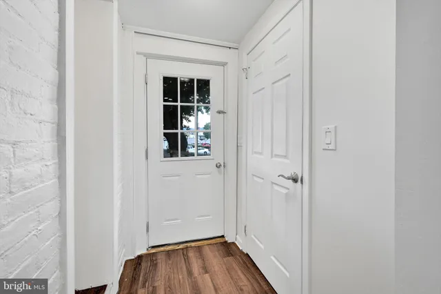 a view of a hallway with wooden floor and closet