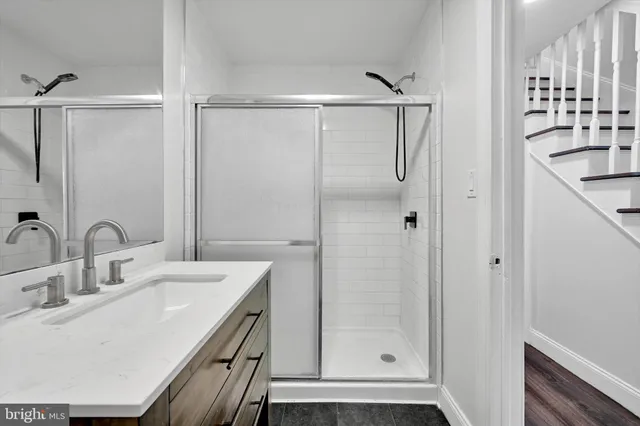 a bathroom with a shower sink vanity and mirror