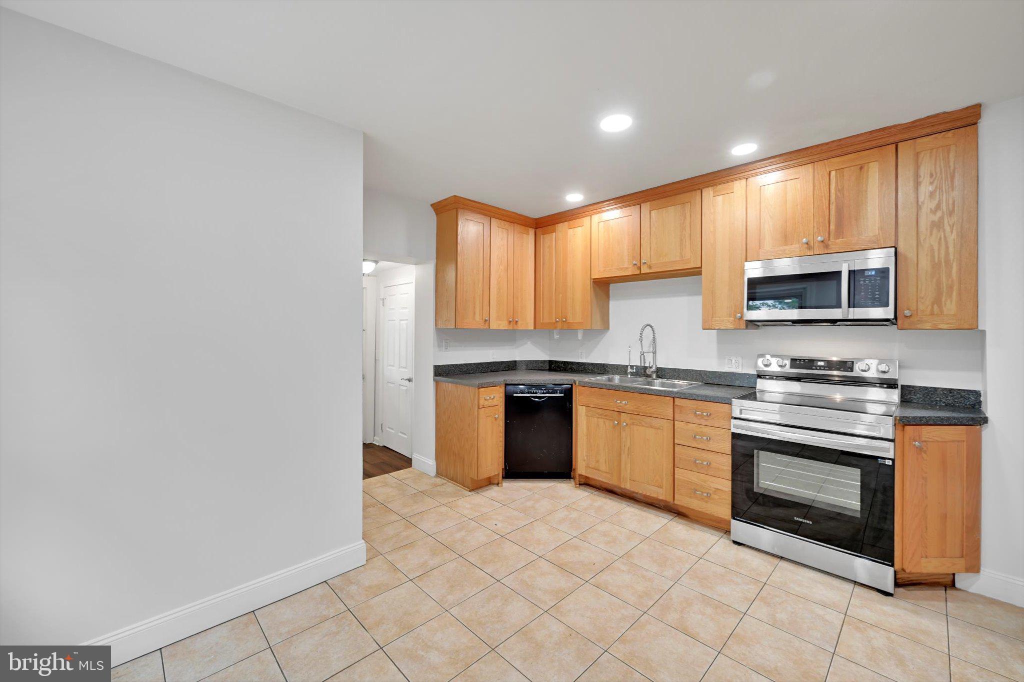 3964 Penn Avenue Sinking Spring, PA 19608 - Photo 9 of 30 a kitchen with stainless steel appliances granite countertop a stove top oven a sink and dishwasher