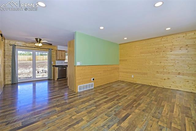 1914 Wooten Road Colorado Springs, CO 80915 - Photo 10 of 39 Unfurnished room featuring wood walls, dark wood finished floors, recessed lighting, and a ceiling fan