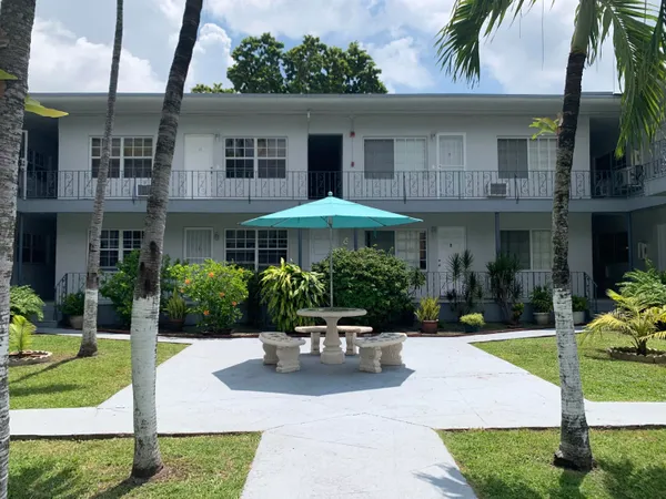 a front view of a house with porch and garden