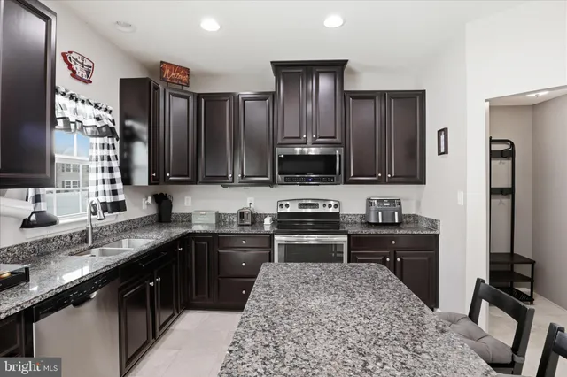 a kitchen with stainless steel appliances granite countertop a refrigerator stove and sink
