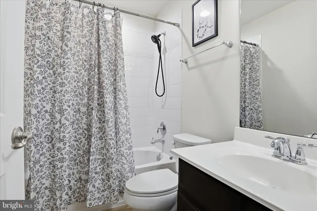 a bathroom with a granite countertop sink a toilet and shower
