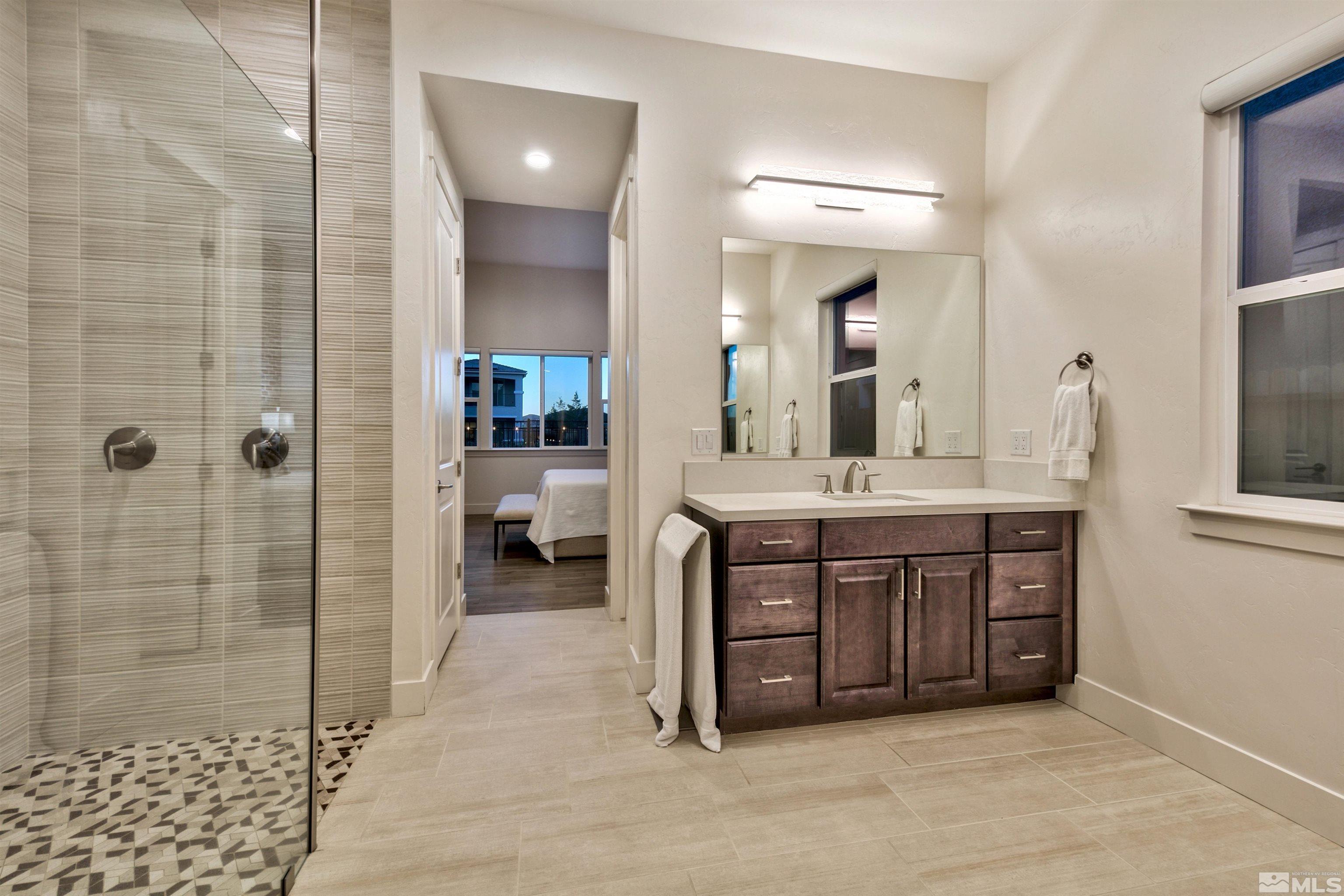 2385 Buttermere Drive Reno, NV 89521 - Photo 15 of 40 a bathroom with a double vanity sink a toilet a mirror and shower