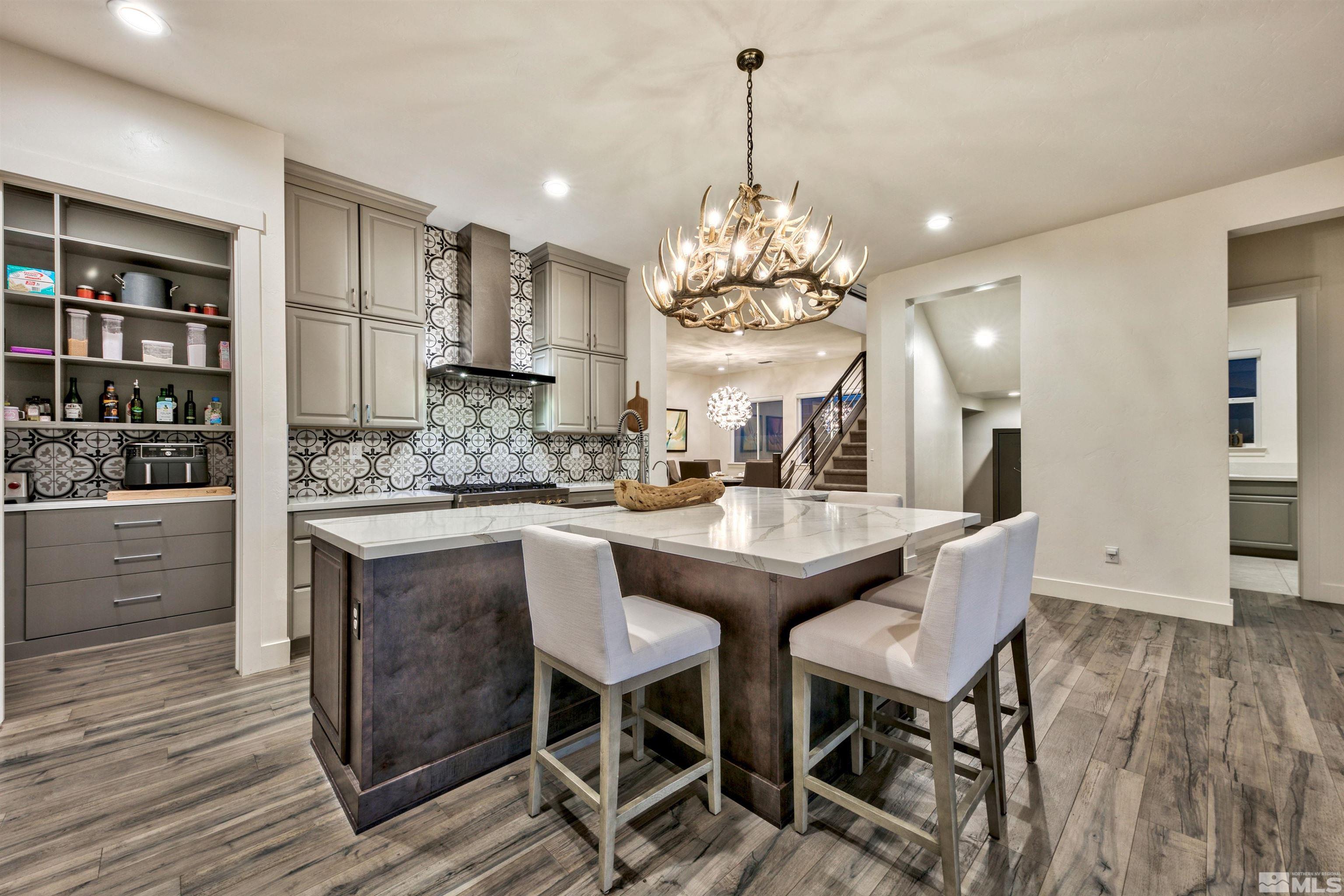 2385 Buttermere Drive Reno, NV 89521 - Photo 5 of 40 a kitchen with stainless steel appliances kitchen island granite countertop a table and chairs in it