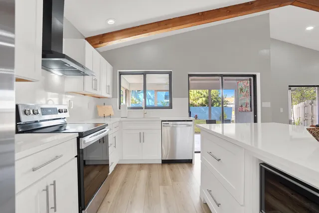 a kitchen with granite countertop white cabinets and white appliances