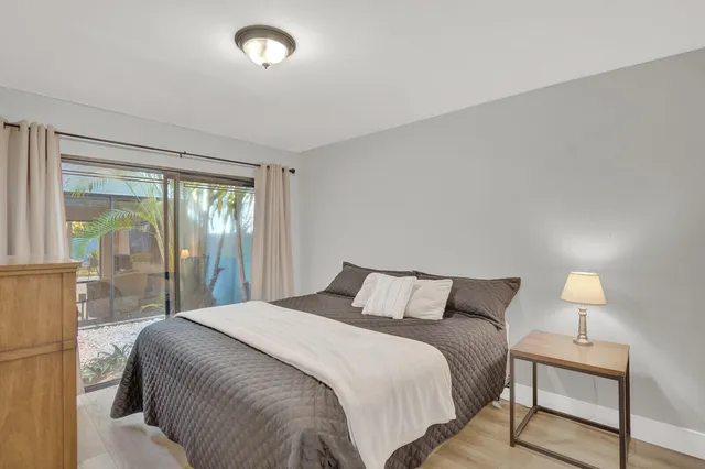 a bedroom with a large bed and a lamp next to a window