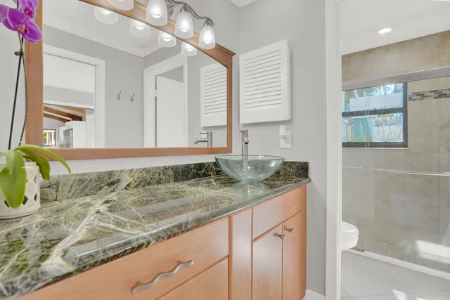 a bathroom with a granite countertop sink and a mirror