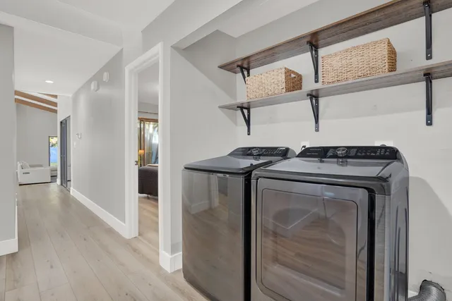 a utility room with wooden floor washer and dryer