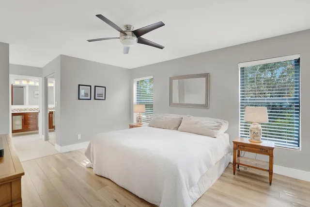 a bedroom with a large bed a chandelier and a window