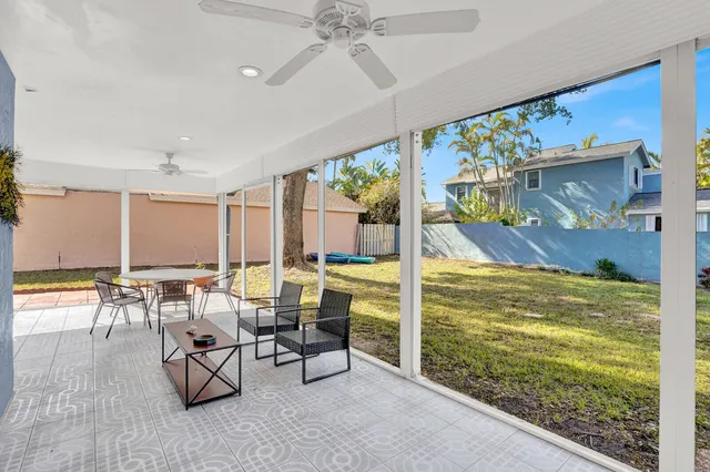 a living room with patio furniture and a floor to ceiling window