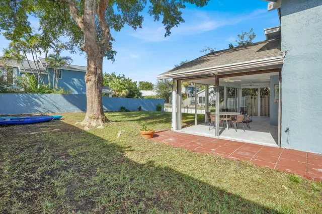 a view of a patio with table and chairs potted plants and palm tree