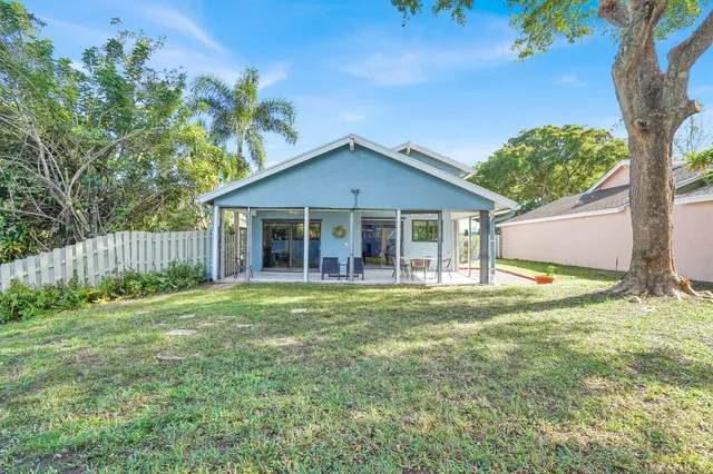 a brick house with a big yard and large trees