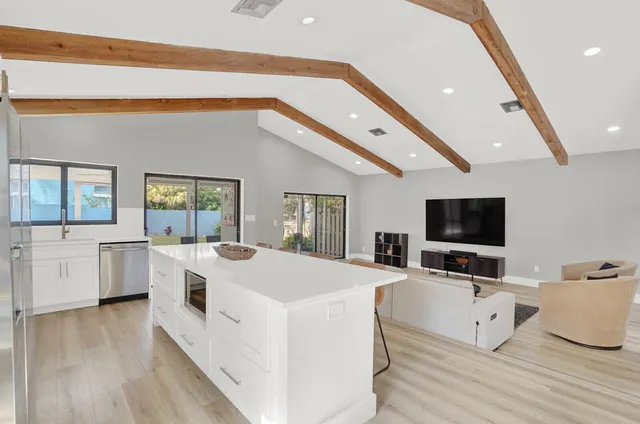 a living room with white furniture and flat screen tv