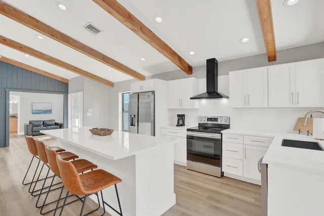 a kitchen with stainless steel appliances a sink a stove top oven a counter space and cabinets