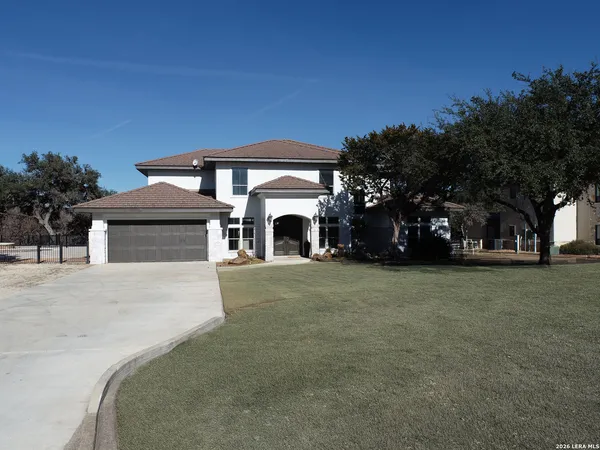 a front view of a house with a garden and trees