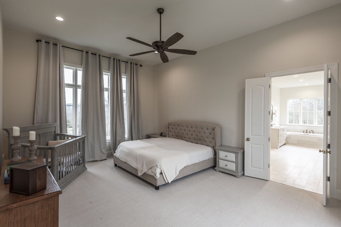 197 E Bugg Hollow Road Cottontown, TN 37048 - Photo 32 of 61 a bedroom with a bed and a chandelier