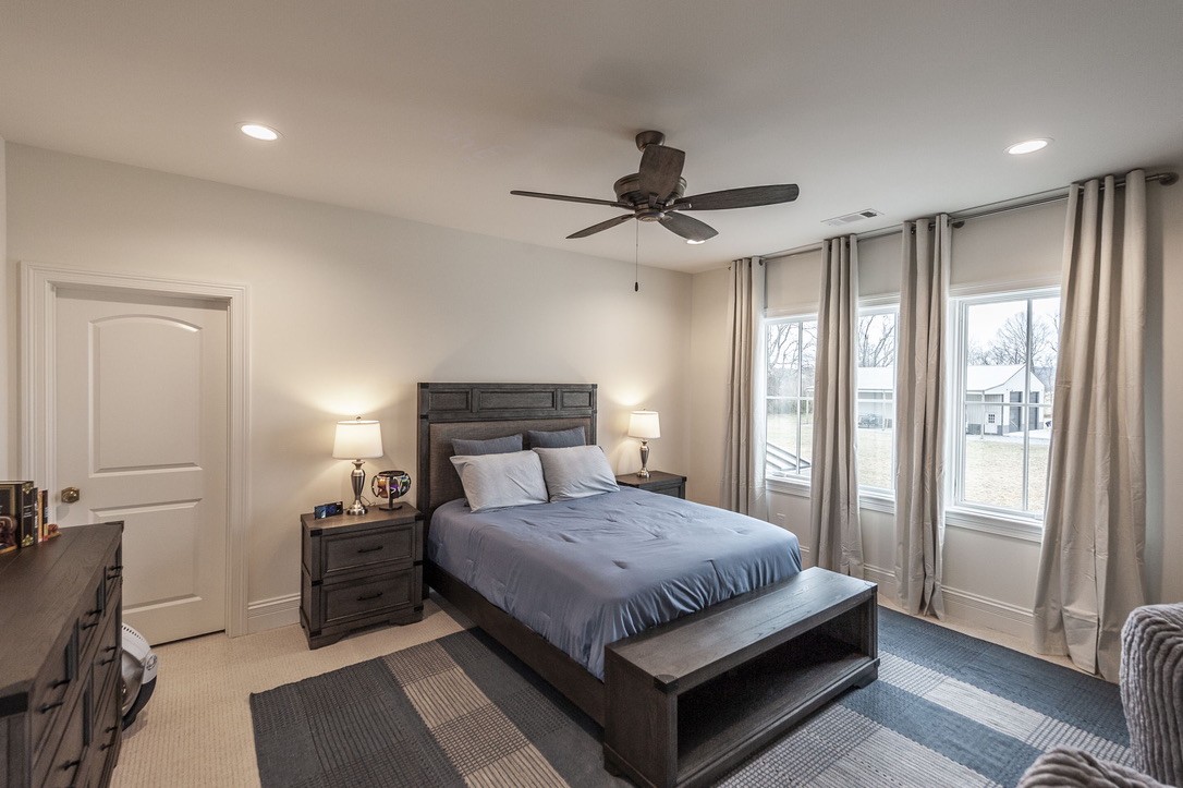 197 E Bugg Hollow Road Cottontown, TN 37048 - Photo 45 of 61 a bedroom with a large bed and a chandelier