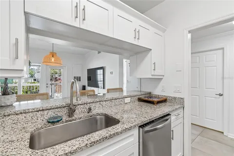 a kitchen with granite countertop a sink a stove and cabinets