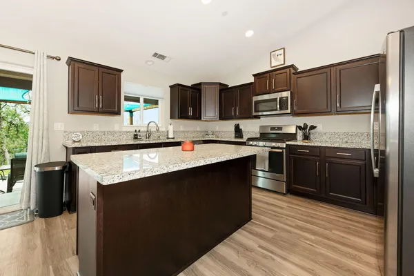a kitchen with stainless steel appliances granite countertop a sink stove and refrigerator