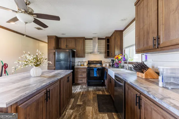 a kitchen with granite countertop a sink a counter space appliances and cabinets