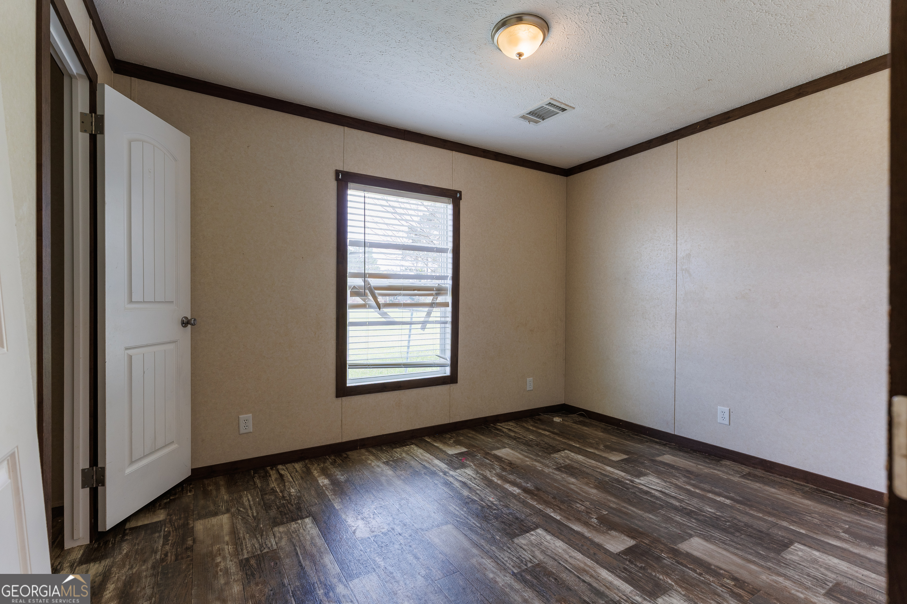 1121 Futch Road Adel, GA 31620 - Photo 18 of 28 an empty room with wooden floor and windows