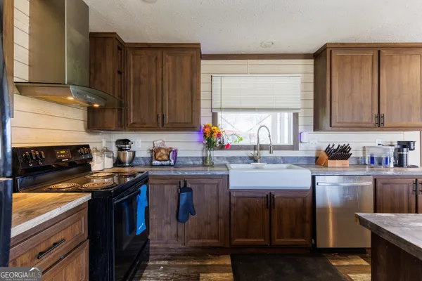 a kitchen with stainless steel appliances granite countertop a sink stove and cabinets