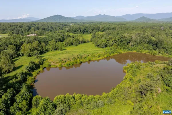 a view of a lake with green field and mountains