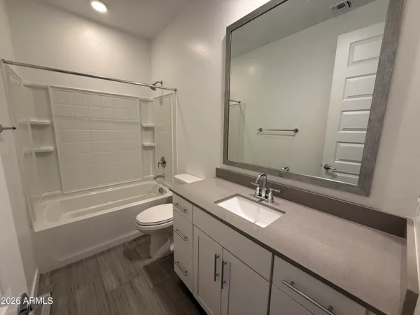 a bathroom with a double vanity sink toilet mirror and shower