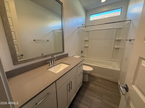 a bathroom with a granite countertop sink toilet a large mirror a bathtub and shower