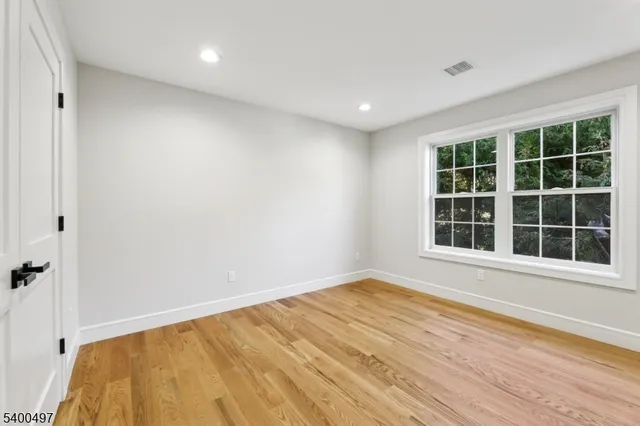 an empty room with windows and ceiling fan