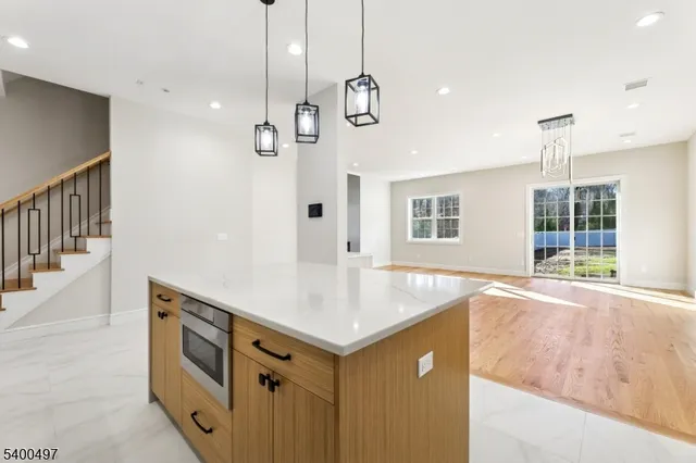 a view of an empty room with wooden floor and windows