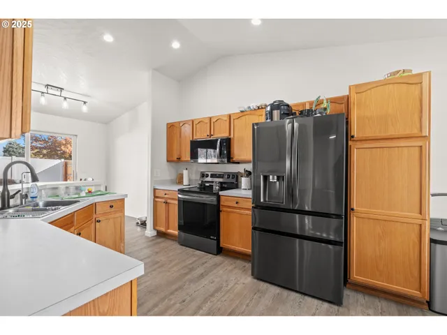 a kitchen with stainless steel appliances granite countertop a refrigerator and a sink