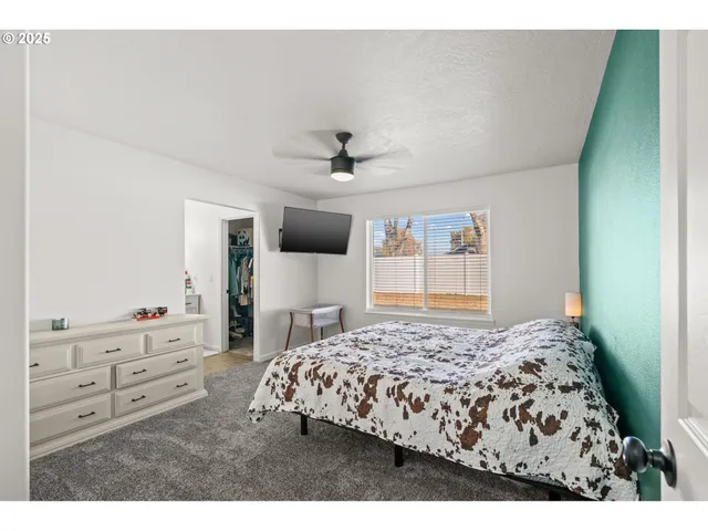 a bedroom with a bed a window and a chandelier